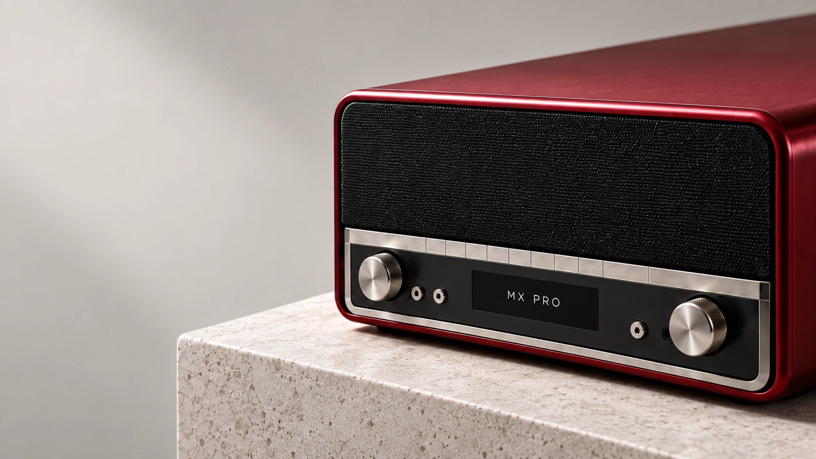 Oxblood retro radio with metal controls on a stone plinth